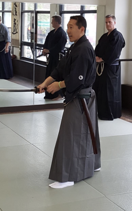 Japanese man in traditional clothing wielding a katana